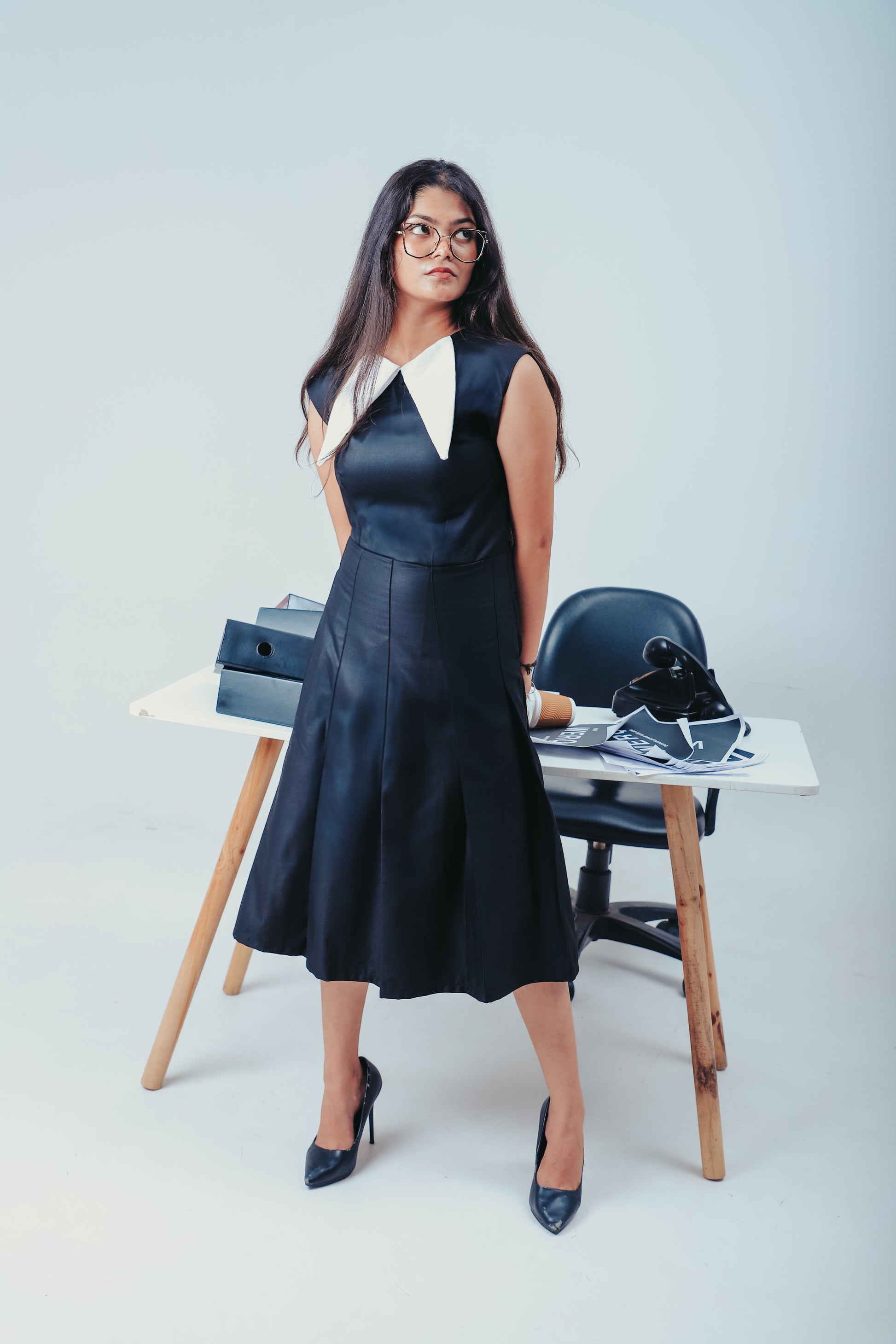 black pleated work dress, WERQ office fashion, sharp white collar dress, Indian women’s formalwear, smart collared dress for office, bold pleated black dress, structured professional outfit, tailored black officewear, modern Indian formal style, WERQ desi